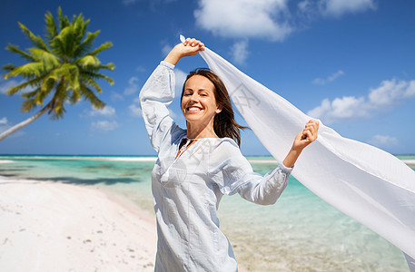人与休闲的快乐的女人与披肩风中挥动热带海滩背景法属波利尼西亚快乐的女人,披肩海滩上迎风飘扬图片