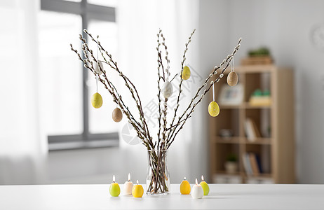 节日象柳枝装饰复活节鸡蛋花瓶蜡烛桌子上猫柳枝装饰复活节彩蛋背景图片