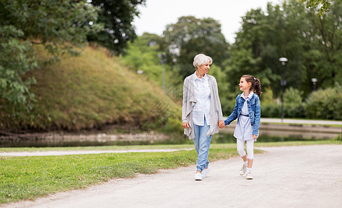 家庭休闲人的快乐的祖母孙女夏季公园散步祖母孙女公园散步图片