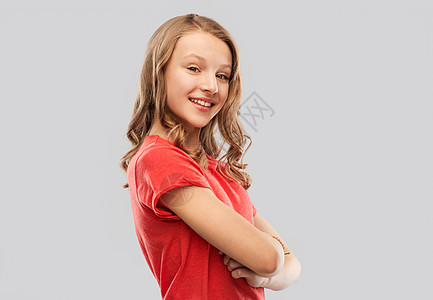 人们的微笑的十几岁女孩,长发红色T恤灰色背景微笑的十几岁女孩穿着红色T恤,灰色图片