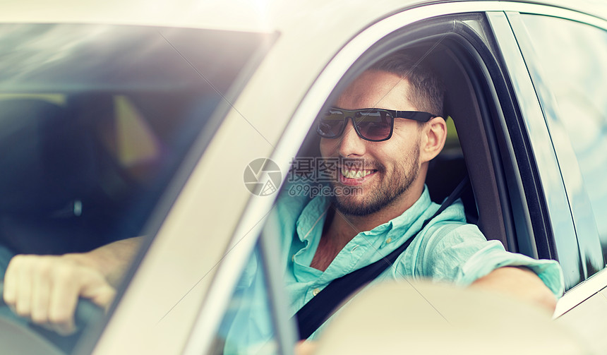 人的快乐的微笑男人戴着太阳镜驾驶汽车戴太阳镜开车的快乐微笑的人