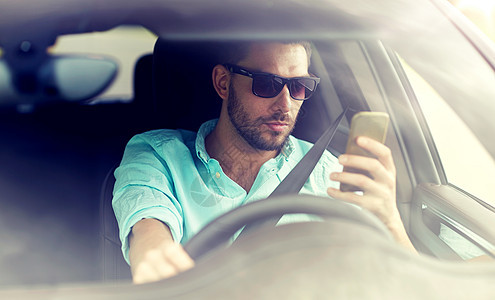 公路旅行,交通,旅行,技术人的戴太阳镜的人驾驶智能手机汽车戴太阳镜的男人开着智能手机的车图片