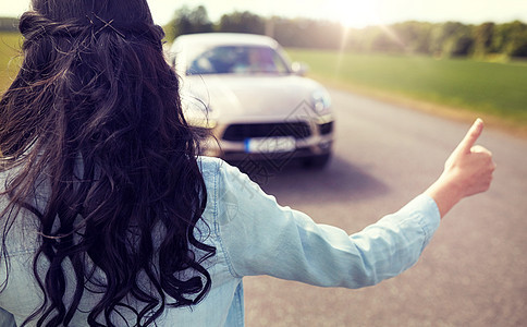 公路旅行,旅行,手势人的女人搭便车停车与拇指手势农村女人搭便车,竖大拇指停车图片