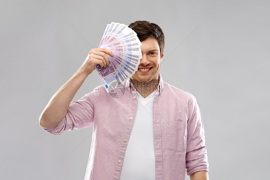 ‘~金钱金融商业人的微笑的轻人,着五百欧元的钞票,背景灰色的微笑的轻人,欧元的球迷超过灰色  ~’ 的图片