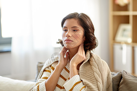 寒冷健康问题的生病的女人触摸她的淋巴结家里生病的女人家里摸她的淋巴结图片