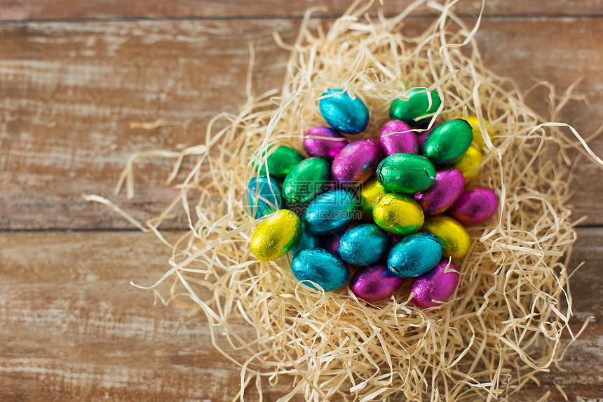 复活节 糖果假日巧克力鸡蛋箔纸包装稻草巢木背景稻草巢箔包装纸中的巧克力蛋高清图片下载 正版图片 摄图网