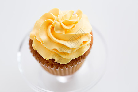 食品,糕点糖果纸杯蛋糕与黄色奶油霜璃糖果站白色背景蛋糕上糖霜图片