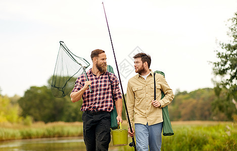 休闲人们的快乐的朋友与钓竿舀网沿着码头湖泊河流湖边河边鱼竿网的朋友图片