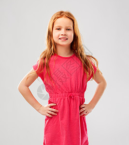 童人们的微笑的红头发女孩摆粉红色的裙子灰色的背景微笑的红头发女孩摆着粉红色的裙子图片