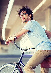 人,风格,休闲生活方式轻的时髦男子骑固定齿轮自行车城市街道轻的时髦男子骑固定齿轮自行车图片