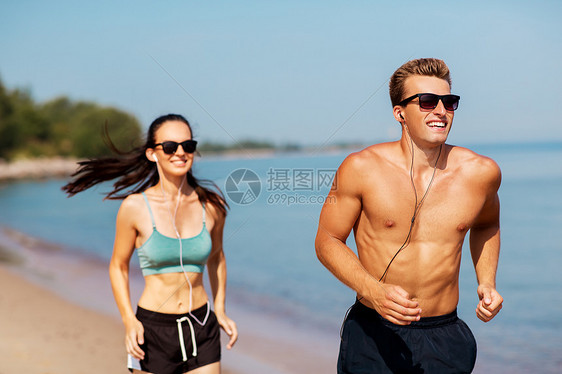 健身,运动技术快乐的夫妇与耳机运行夏季海滩夫妇带着耳机海滩上跑来跑图片