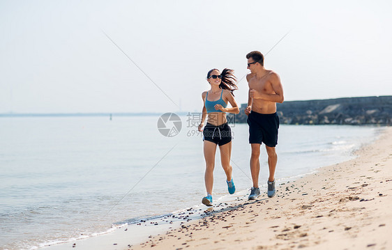 健身,运动生活方式的快乐的夫妇穿着运动服装太阳镜沿着夏季海滩跑步穿着运动服的夫妇海滩上跑步图片