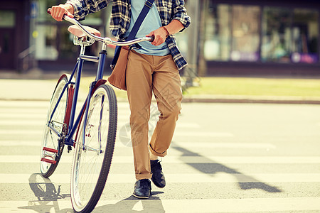 人,风格,城市生活生活方式轻的时尚男子肩袋固定齿轮自行车肩袋跨越人行横道街上人行横道上骑固定齿轮自行车的轻人图片