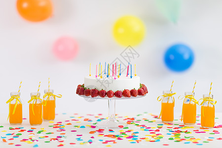 派食品节日生日蛋糕与蜡烛草莓,饮料,爆米花棉花糖桌子上生日蛋糕,果汁,爆米花棉花糖图片