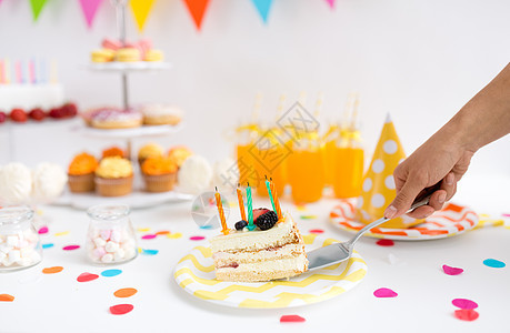 食物庆祝节日生日聚会上用铲子把块蛋糕蜡烛放盘子上手把生日蛋糕放盘子里图片