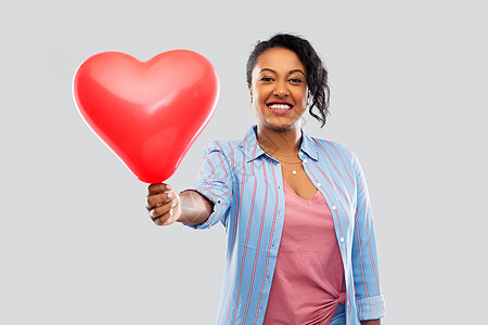 情人节人们的快乐的非裔美国轻妇女与红色心形气球灰色背景带心形气球的非裔美国妇女图片
