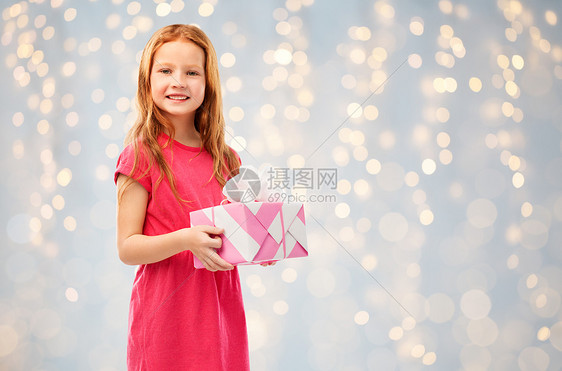 生日人们的微笑的红头发女孩与礼品盒节日的灯光背景微笑的红头发女孩带着生日礼物图片