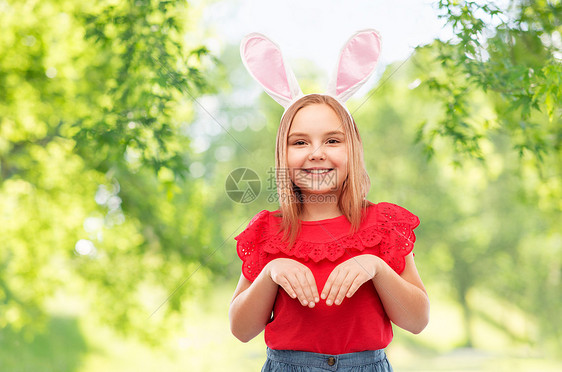 复活节,假期童的快乐的女孩戴着兔子耳朵头巾绿色的自然背景快乐的女孩戴着复活节兔子耳朵头巾图片