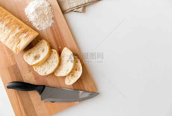 食物,垃圾食品健康的饮食白色西巴塔包木制切割板,刀厨房毛巾切割板上的白色Ciabatta包图片