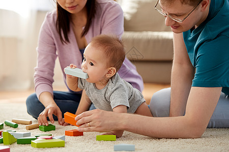 混血家庭,父母人的快乐的母亲,父亲男孩家里玩玩具积木幸福的家庭男孩家里玩耍图片