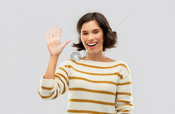 计数人们的快乐的微笑轻妇女穿条纹套衫,五个手指的只手灰色的背景快乐微笑的女人露出五根手指图片