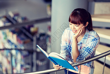 教育,高中,大学,学人的快乐微笑的亚洲学生女孩图书馆楼梯上看书高中生女孩图书馆读书图片