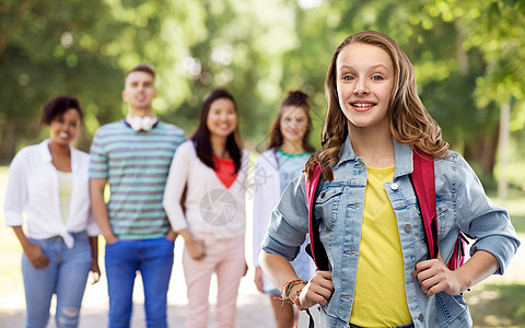 教育,学校人的快乐微笑的十几岁的学生女孩带着包群朋友的夏季公园背景带着书包的快乐微笑的十几岁的学生女孩图片