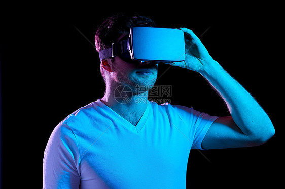 三维技术,虚拟现实,娱乐活动人的轻人VR眼镜上玩游戏,紫外线霓虹灯黑暗的房间虚拟现实耳机VR眼镜中的男人图片