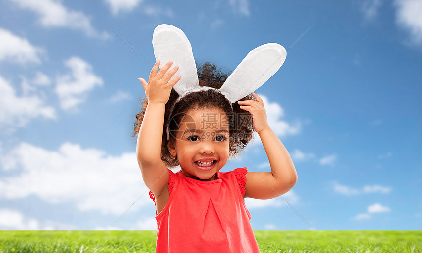 童,派道具复活节快乐的非裔美国女孩戴着兔子耳朵头巾蓝天草地背景快乐的小女孩戴着复活节兔子的耳朵图片