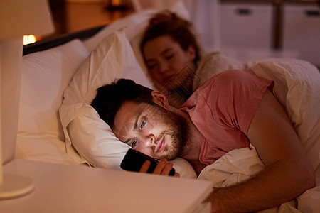 技术,网络成瘾欺骗男人晚上用智能手机,而女朋友正睡觉男人女朋友睡觉的时候用智能手机图片