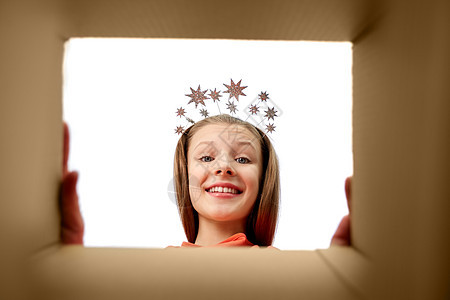 礼物惊喜快乐的惊喜女孩派皇冠上寻找打开的礼品盒戴着皇冠的快乐女孩看着打开的礼品盒图片