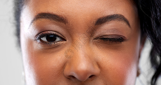 视觉,化妆人的特写非裔美国妇女的脸眨眼特写非裔美国妇女眨着只眼睛图片