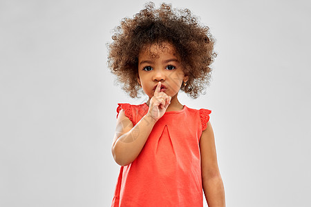 童人的小非裔美国女孩灰色背景上嘘声手势小非裔美国女孩着嘘的手势图片