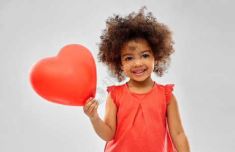 童人的快乐的非裔美国女孩与红色心形气球灰色背景带心形气球的非裔美国女孩图片