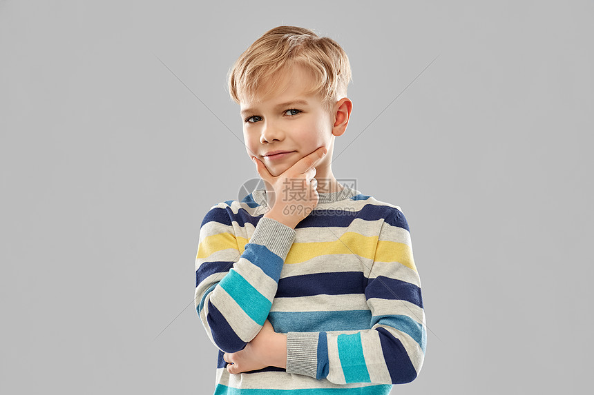 童,表情人的微笑的小男孩条纹套头衫思考灰色背景条纹套衫思考男孩的肖像图片