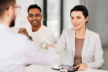 工作招聘就业国际招聘队与男员工进行试并办公室握手招聘人员与员工谈图片