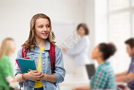 教育,学校人的快乐微笑的十几岁的学生女孩带着书包书教室背景下带着书包的快乐微笑的十几岁的学生女孩图片