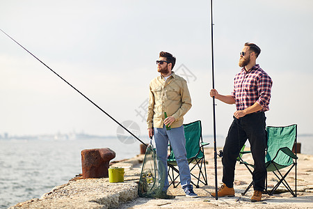 休闲人们的快乐的朋友与钓鱼竿啤酒码头海上码头上钓鱼竿啤酒的快乐朋友图片