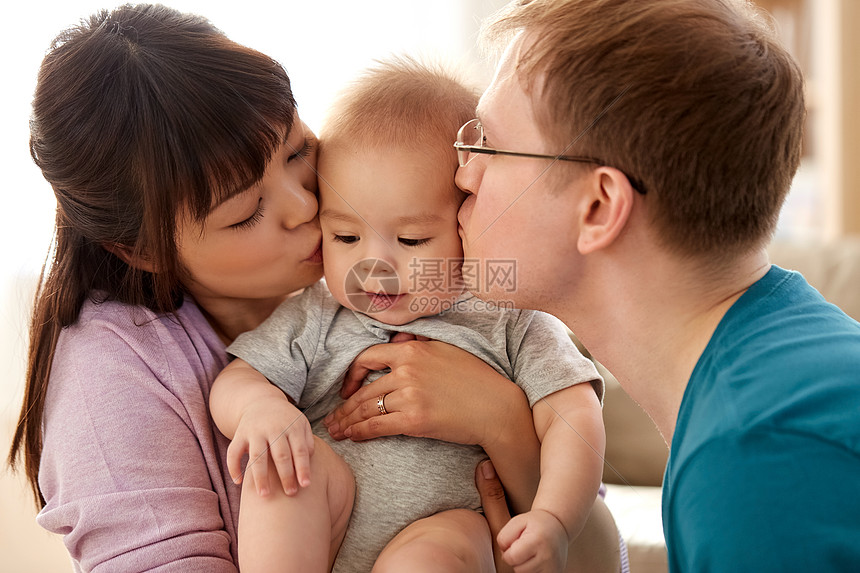 混血家庭,父母人的快乐的母亲父亲亲吻他们的孩子家里快乐的母亲父亲家里亲吻小儿子图片
