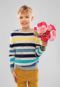 生日,童人的微笑的小男孩与牡丹花灰色的背景微笑的男孩带着牡丹花图片