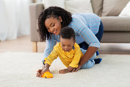 童,孩子人的快乐的非裔美国母亲她的小儿子玩玩具汽车家里的沙发上妈妈宝宝家玩玩具车图片