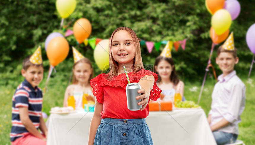 饮料人们的微笑的青春期前女孩喝汽水罐头与纸吸管生日聚会夏季公园微笑的女孩可以生日聚会上喝酒图片