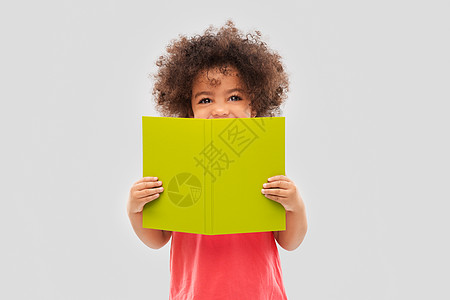 童,文学阅读快乐的非裔美国女孩与书灰色背景快乐的非裔美国女孩带着书图片
