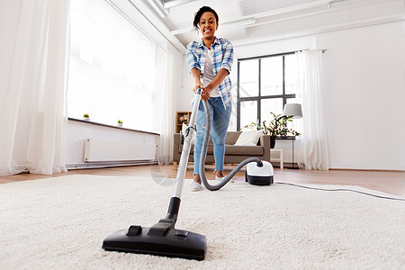 家庭,家务清洁快乐的非裔美国妇女家庭主妇与吸尘器家里家里吸尘器的女人家庭主妇图片