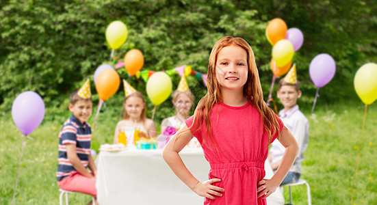 童人们的微笑的红头发女孩夏季公园背景的生日聚会上穿着粉红色的衣服生日聚会上微笑的红头发女孩图片