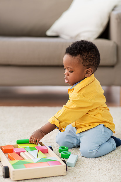 童,孩子人的可爱的非裔美国小男孩玩木制玩具积木套件地板上家里非裔美国小男孩玩玩具积木图片