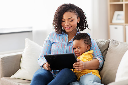 家庭,母亲技术快乐的非裔美国母亲用平板电脑与小儿子家母亲用平板电脑与婴儿儿子家图片