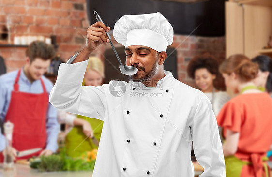 烹饪课,职业人的快乐的印度男厨师品尝食物瓢超过学生的背景厨师烹饪课上品尝食物图片
