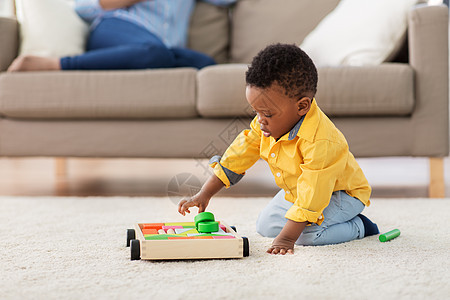 童,孩子人的可爱的非裔美国小男孩玩木制玩具积木套件地板上家里非裔美国小男孩玩玩具积木图片