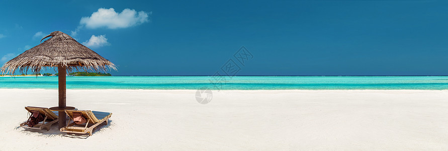 浪漫的度假热带海滩与两个太阳床下的帕拉帕心形云马尔代夫马尔代夫海滩帕拉帕下的两个太阳床图片